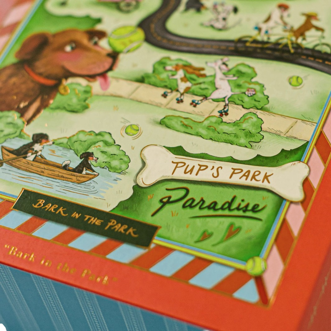 Bark in the Park 500-piece dog jigsaw puzzle with playful pups and gold foil details in a magnetic keepsake box