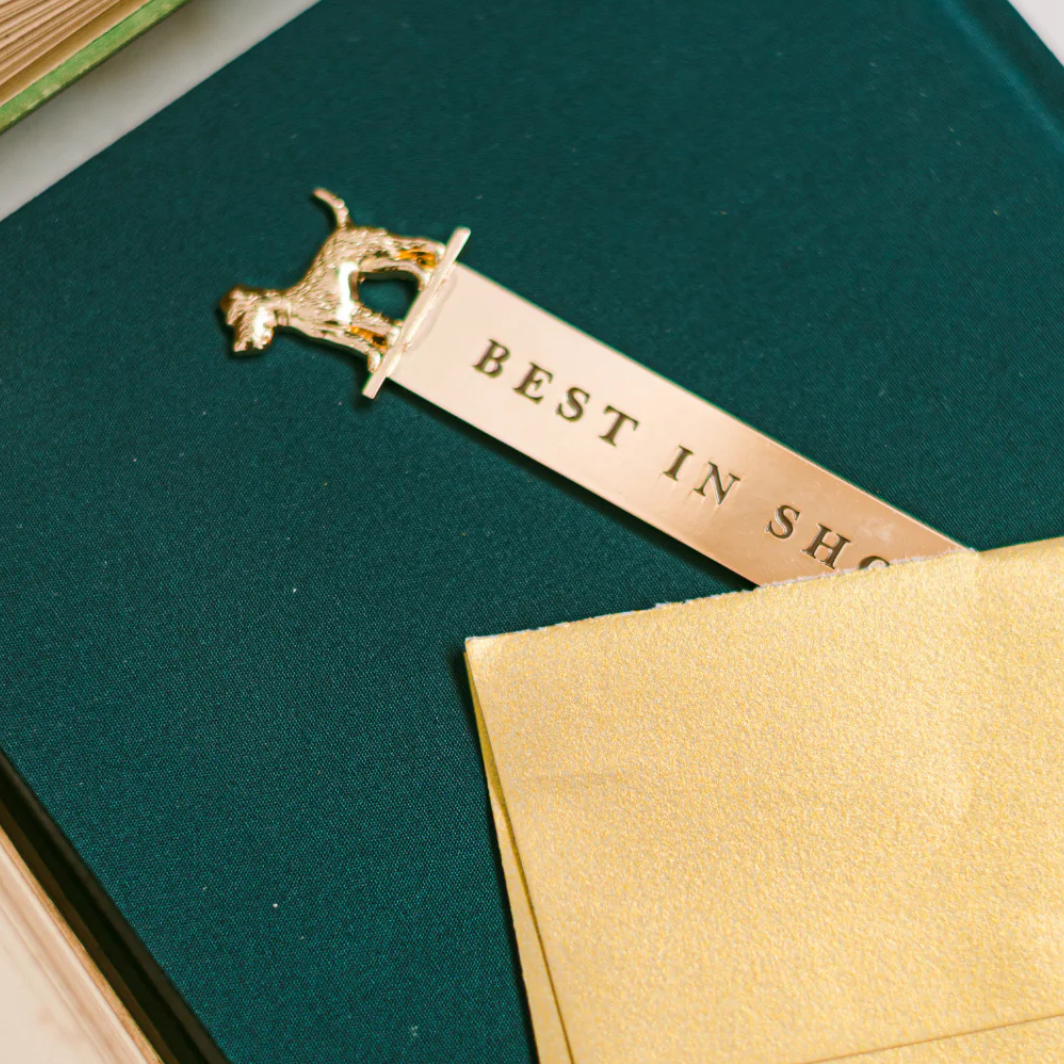 Polished metal dog-shaped bookmark and letter opener with vegan leather sleeve in foil-stamped box
