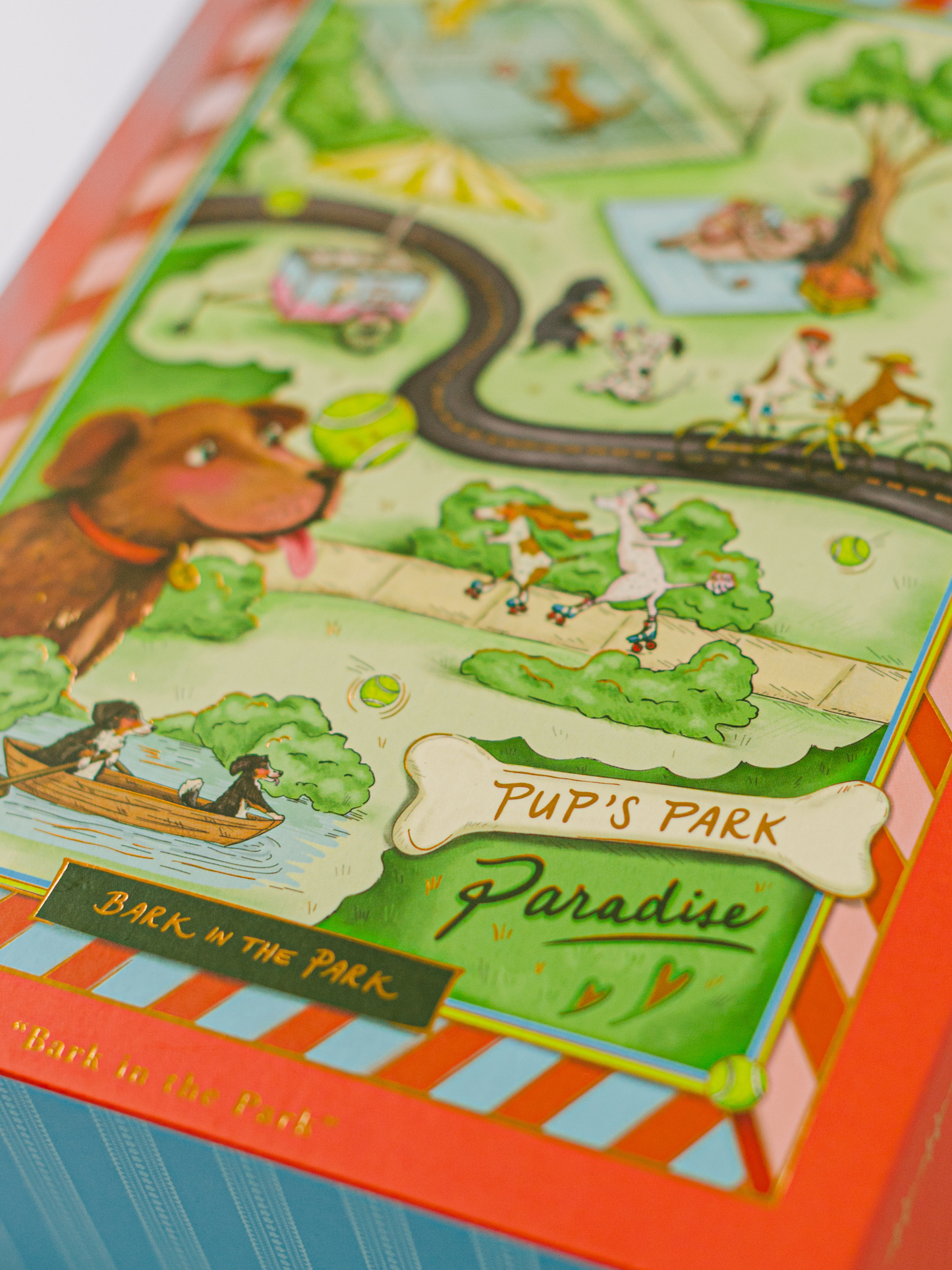 Bark in the Park 500-piece dog jigsaw puzzle with playful pups and gold foil details in a magnetic keepsake box