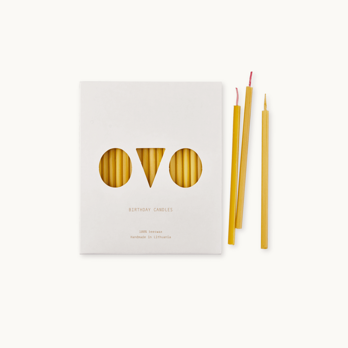 Set of birthday beeswax candles with packaging labeled 'OVO' on a light background.