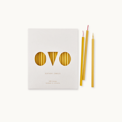 Set of birthday beeswax candles with packaging labeled 'OVO' on a light background.