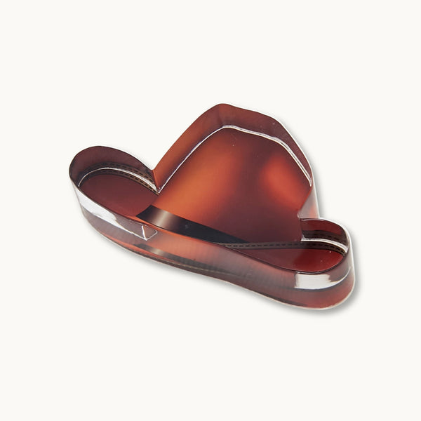 A clear brown cowboy hat acrylic paperweight, napkin weight, or home decor.