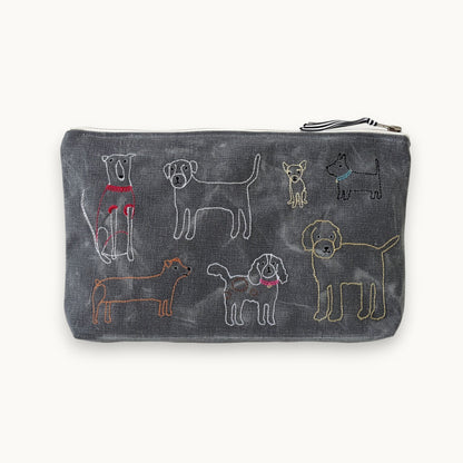 A dark gray zippered pouch featuring embroidered dog illustrations in various colors on a light off-white background.