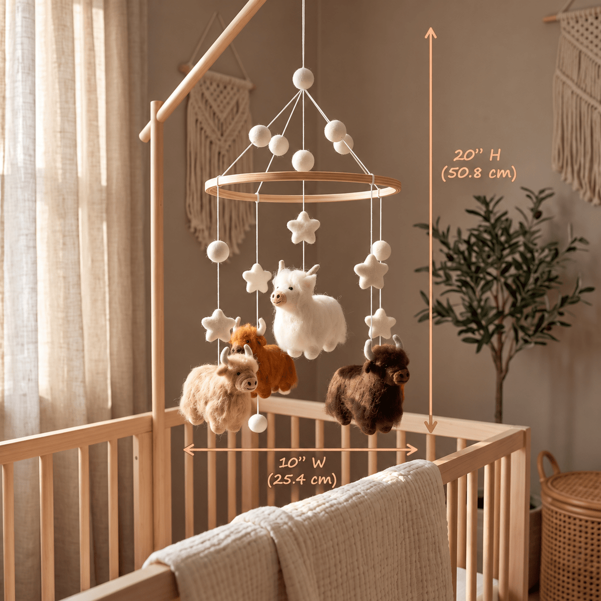 Handcrafted Highland cow felt baby mobile featuring fluffy cows in cream, caramel, and chocolate brown, with felt stars and wooden hoop, hanging above a natural wood crib in a neutral nursery.