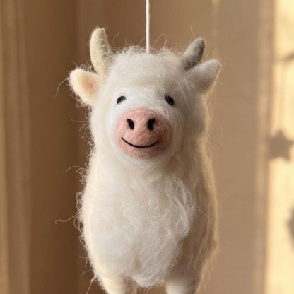 Handcrafted Highland cow felt baby mobile featuring fluffy cow in cream.